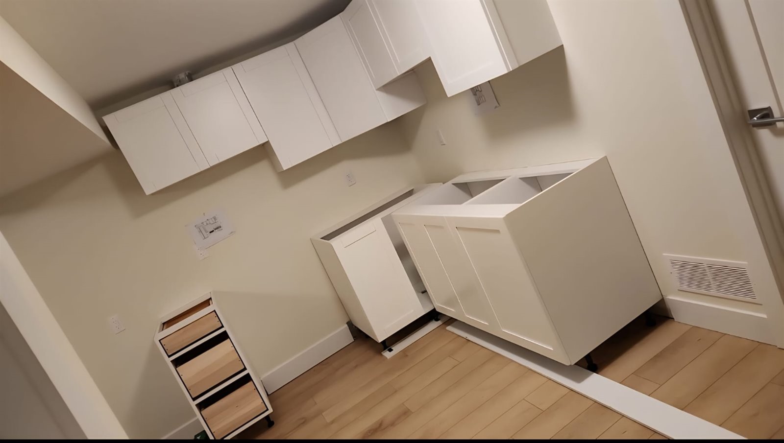 Angled view of white kitchen cabinet installation