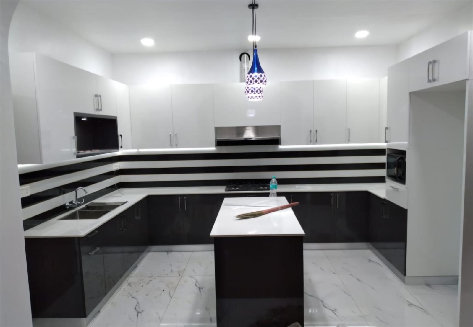 Monochrome kitchen cabinet installation with dark counters