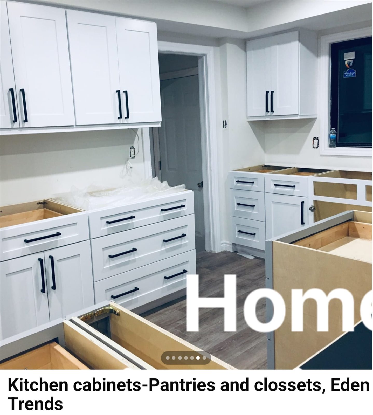 Open plan white kitchen cabinet installation