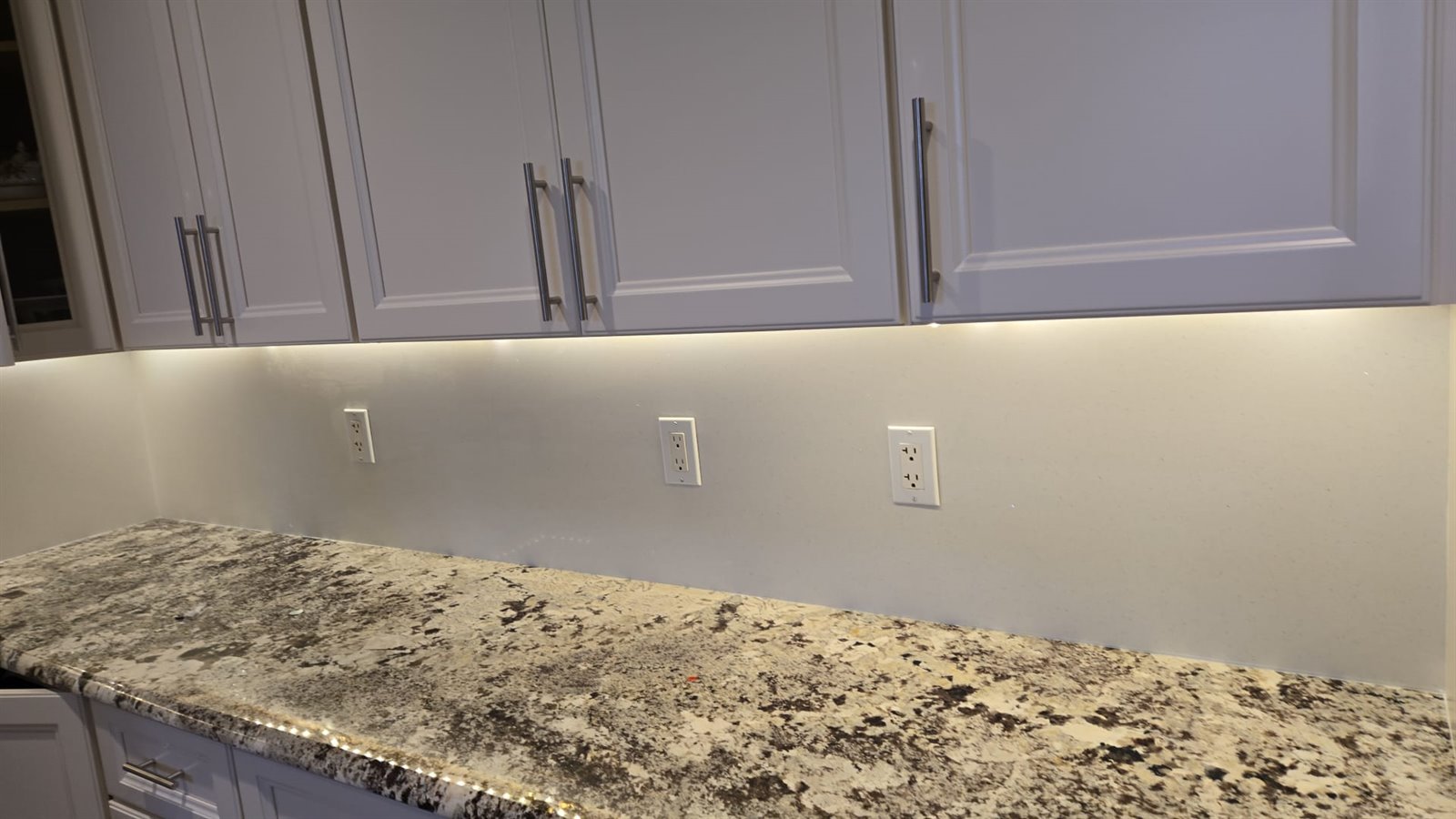 Under cabinet lighting detail above stone countertop