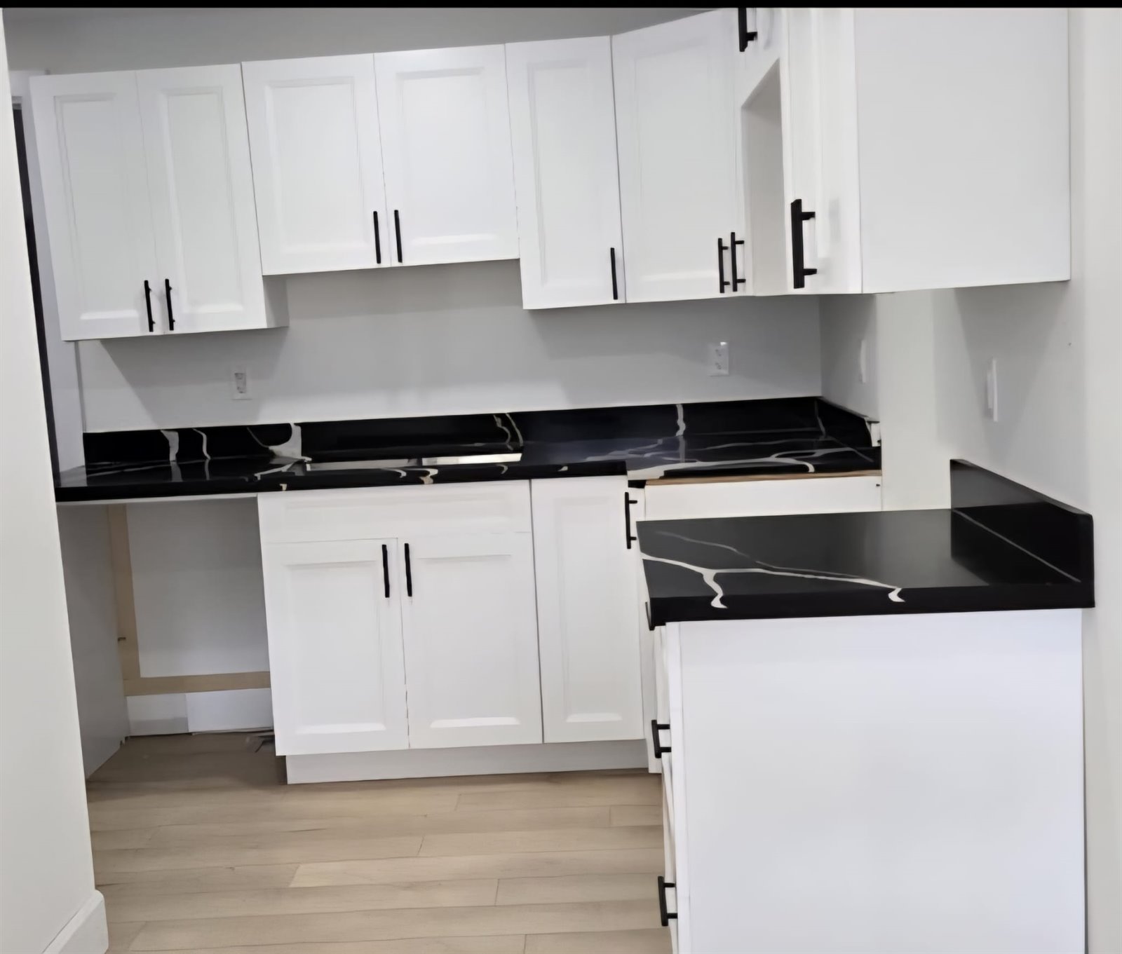 White shaker kitchen cabinets with dark countertop
